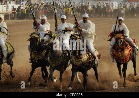 Uomini a cavallo che trasportano le pistole, festival di fantasia per il Moussem di Moulay Abdallah nei pressi di el-Jadida, Costa Atlantica, Marocco, Af Foto Stock