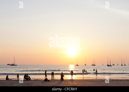 Persone a Nai Harn Beach al tramonto, Phuket, Thailandia, Asia Foto Stock