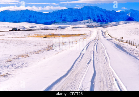 Strada che conduce verso le montagne in inverno, Longview, Alberta, Canada Foto Stock
