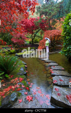 La donna nel giardino giapponese in autunno a Butchart Gardens, Victoria, Isola di Vancouver, British Columbia, Canada Foto Stock
