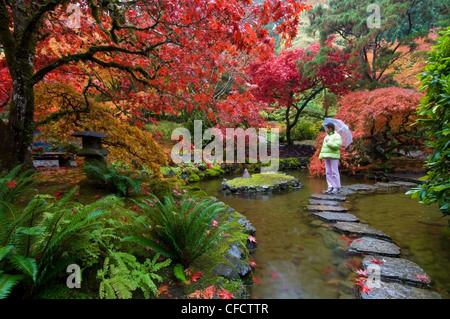 La donna nel giardino giapponese in autunno a Butchart Gardens, Victoria, Isola di Vancouver, British Columbia, Canada Foto Stock