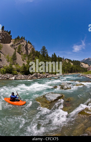 Un maschio di kayaker pagaie il fiume Wigwam, classe 4 in Fernie, British Columbia, Canada Foto Stock