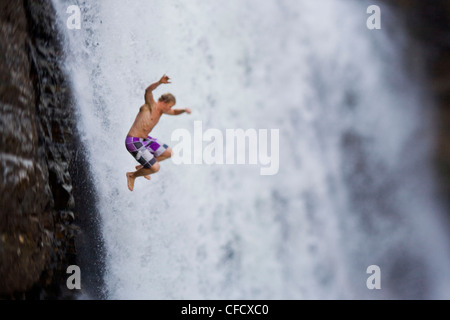 Un giovane uomo ciff immersioni subacquee a Moyie Falls, Cranbrook, British Columbia, Canada Foto Stock