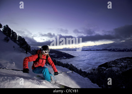 Sciatore femmina nella neve profonda al crepuscolo, Chandolin, Anniviers, Vallese, Svizzera Foto Stock