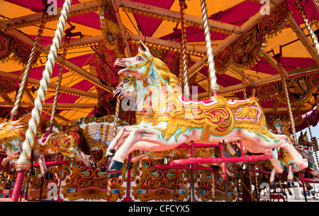In vecchio stile cavalli in legno su merry-go-round, Plymouth UK Foto Stock