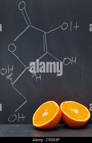 Formula di struttura della vitamina C sulla lavagna con Orange Foto Stock