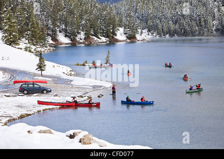 Giovani ragazzi canoa in due Jack Lago dopo una recente nevicata. Il Parco Nazionale di Banff, Alberta, Canada. Foto Stock