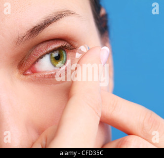 Occhio umano con lenti correttive su uno sfondo blu Foto Stock