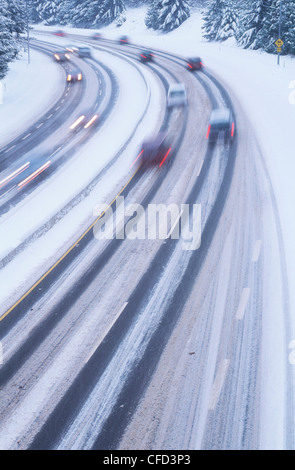 Autostrada nevoso al crepuscolo con striature chiare di vetture, British Columbia, Canada. Foto Stock