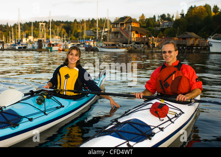Kayakers paletta nella parte anteriore del villaggio, Cowichan Bay, l'isola di Vancouver, British Columbia, Canada. Foto Stock