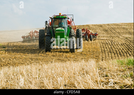 Trattore in movimento e aria fino a una seminatrice di piantare la canola in uno zero fino a grano campo di stoppie, Bruxelles, Manitoba, Canada Foto Stock