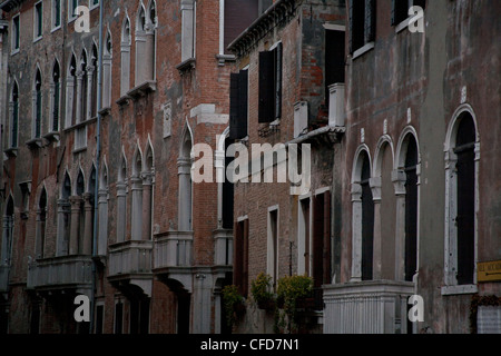 Fila di edifici veneziani con arcate e finestre con persiane, Venezia Italia Foto Stock