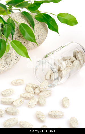 Supplemento a base di erbe pillole fuoriuscita della bottiglia - medicina alternativa concetto - isolato Foto Stock