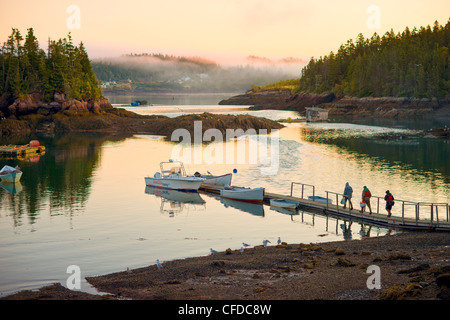 I pescatori neri di lasciare il porto all'alba, la baia di Fundy, New Brunswick, Canada Foto Stock