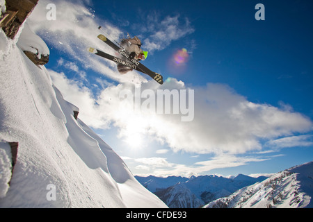 Un giovane maschio sciatore arie una scogliera in Kicking Horse backcountry, Golden, Britsh Columbia, Canada Foto Stock