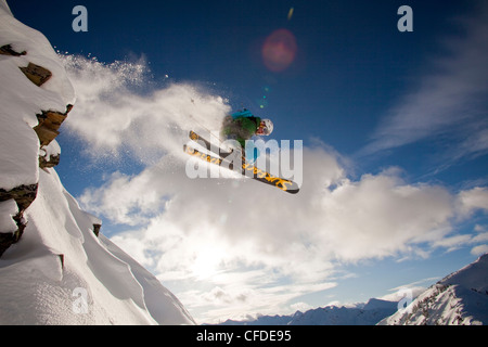 Un giovane maschio sciatore arie una scogliera in Kicking Horse backcountry, Golden, Britsh Columbia, Canada Foto Stock