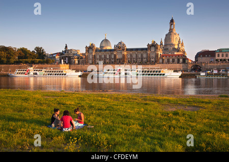 Giovani donne avente picnic presso il fiume Elba, Bruehlsche Terrasse e Frauenkirche in background, Dresda, Sassonia, Germania, Foto Stock