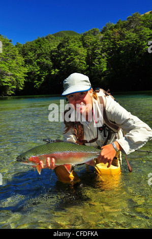 Donna che mantiene la trota arcobaleno, Nuova Zelanda Foto Stock