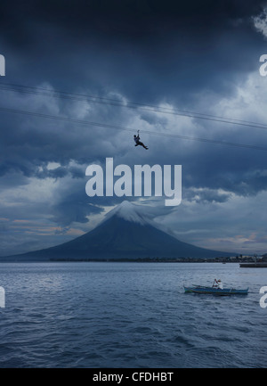 Uomo sulla zipline e fisherman con il vulcano Mayon, Legazpi City, isola di Luzon, Filippine, Asia Foto Stock