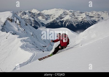 Giovane uomo polvere di sci presso il Lago Louise Ski Area, il Parco Nazionale di Banff, Alberta, Canada. Foto Stock