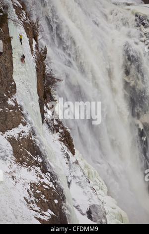 Due scalatori di ghiaccio salire la famosa Montmorency Falls, Quebec, Canada Foto Stock