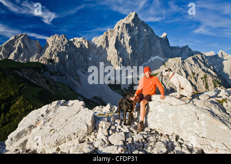Giovane uomo avente un riposo su una roccia, Dachstein, monti Dachstein, Salisburgo, Austria, Europa Foto Stock
