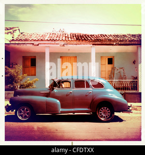 Classic American automobile parcheggiata su una strada con i tradizionali,in background, Trinidad, Cuba, West Indies, America Centrale Foto Stock