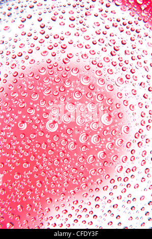 Gocce d'acqua sul vetro di rosso e di colore bianco Foto Stock