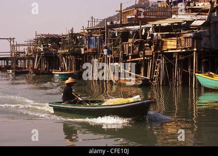 Persona in barca e palafitte, Tai O villaggio sull'Isola di Lantau, off Hong Kong, Cina Foto Stock