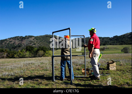 Un giovane cacciatore riceve istruzioni di fucile in corrispondenza di una argilla target range Foto Stock