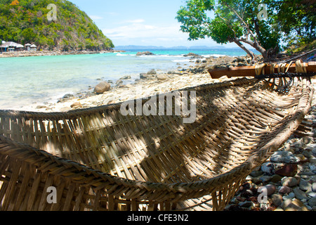 Un ombroso amaca in una remota spiaggia nei pressi di un ristorante nelle Filippine Foto Stock