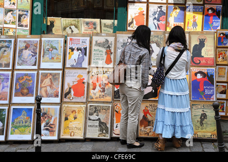 Due donne asiatiche ai turisti la navigazione per negozio di souvenir presso un'arte stallo in Montmartre, Parigi. Foto Stock