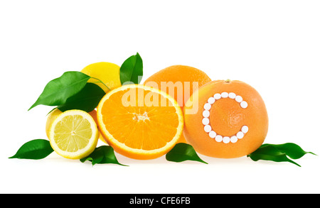 Frutta arancio, limone, pompelmo con vitamina c pillole su sfondo bianco - agrumi concetto - Gruppo - isolato Foto Stock