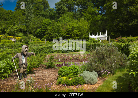 Regno Unito, Gloucestershire, Painswick Casa Giardino rococò, spaventapasseri in orto con dipinti di bianco exedra area salotto oltre Foto Stock