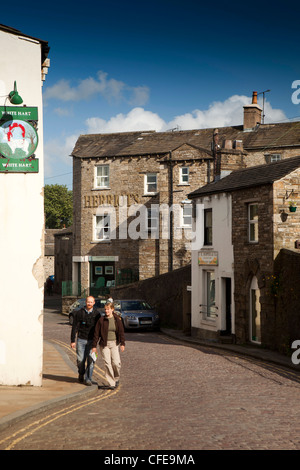 Regno Unito, Inghilterra, Yorkshire, Wensleydale, Hawes, giovane a piedi attraverso il pittoresco villaggio di ciottoli street Foto Stock