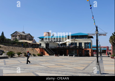 Un ristorante moderno e centro commerciale sul lungomare Luderitz con Woermann Haus sullo sfondo. Luderitz, Namibia. Foto Stock