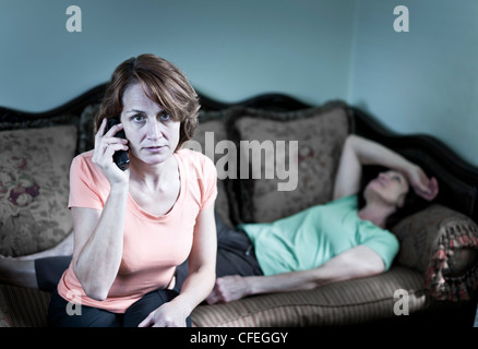 La donna in questione con malati senior madre di emergenza chiamate Foto Stock