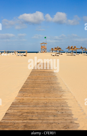 Passerella in legno di fronte spiaggia sabbiosa di vedetta di guardia costiera con la bandiera verde. Praia de Chaves, Rabil, Boa Vista, Isole di Capo Verde Foto Stock