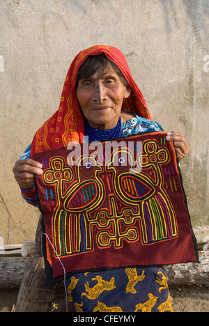 La Kuna donna tenendo un artigianale di mola, Playon Chico Village, isole San Blas (Kuna Yala isole), Panama, America Centrale Foto Stock