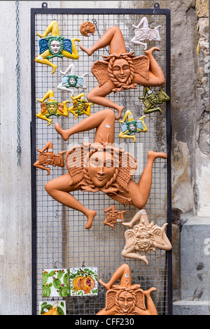 Shop display mostrano rappresentazioni in terracotta dell'antico simbolo della Sicilia, il triskelion o trinacria Foto Stock