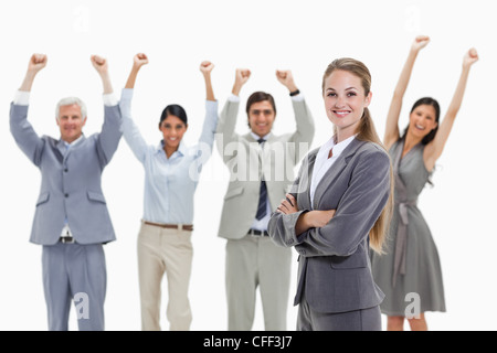 Donna bionda con la gente di affari alzando le braccia Foto Stock