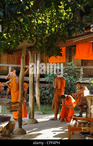 I monaci buddisti, novizio, davanti a loro dimora, Luang Prabang, Laos Foto Stock