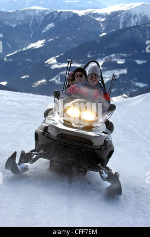 Tre persone su una motoslitta in montagna, Alto Adige, Alto Adige, Italia, Europa Foto Stock