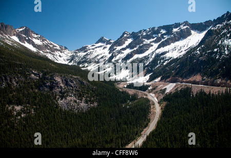 Una strada taglia attraverso un parco nazionale e il verde degli alberi. Foto Stock