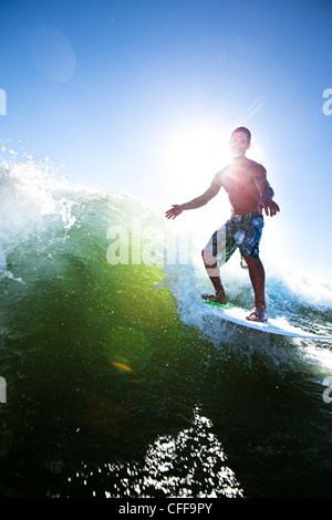 Un maschio atletico surf dietro un wakeboard barca su un lago in Idaho. Foto Stock