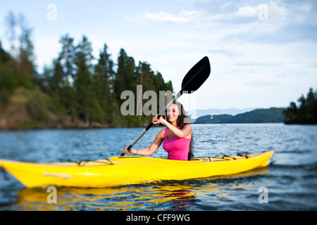 Un felice athletic donna kayak al tramonto su un lago in Idaho. Foto Stock