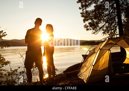 Due giovani adulti ridere e sorridere al tramonto su un campeggio e viaggio in kayak in Idaho. Foto Stock