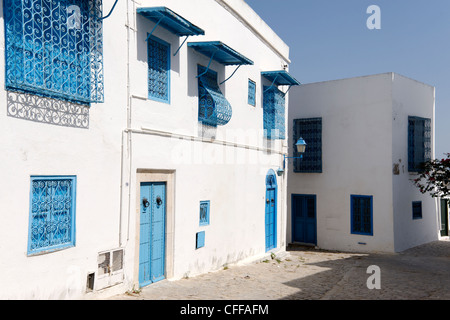 Idi Bou Said. La Tunisia. Vista del tipico alquanto tranquillo vicolo rivestiti con pareti dipinte di bianco e blu di porte e finestre blu Foto Stock