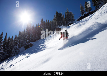 Un athletic snowboarder rip di polvere fresca si trasforma in una giornata di sole in Colorado. Foto Stock