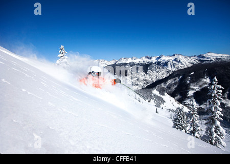 Un athletic sciatore esegue il rip di polvere fresca si trasforma in una giornata di sole in Colorado. Foto Stock